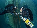 tdi normoxic trimix diver makes a no mask ascent under the gaze of instructor using the Zenobia wreck as a guide